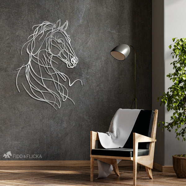Silver metal horse line art wall decor on a dark textured wall in a modern reading nook with armchair, throw blanket, and floor lamp
