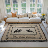 Large personalized woven cotton dressage arena blanket with rider silhouettes, rope border, and custom name displayed in a bright living room.
