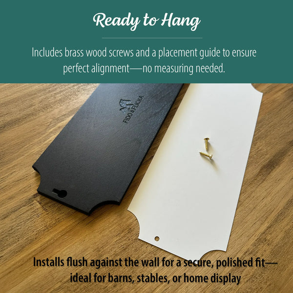 Back side of a black wooden horse stall name plate shown with a white placement guide and brass screws on a wood surface, demonstrating the ready-to-hang installation setup