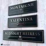 Three luxury personalized horse stall name plates shown in Graphite, Merlot, and Rosé Champagne metallic finishes with custom horse names and emblems.