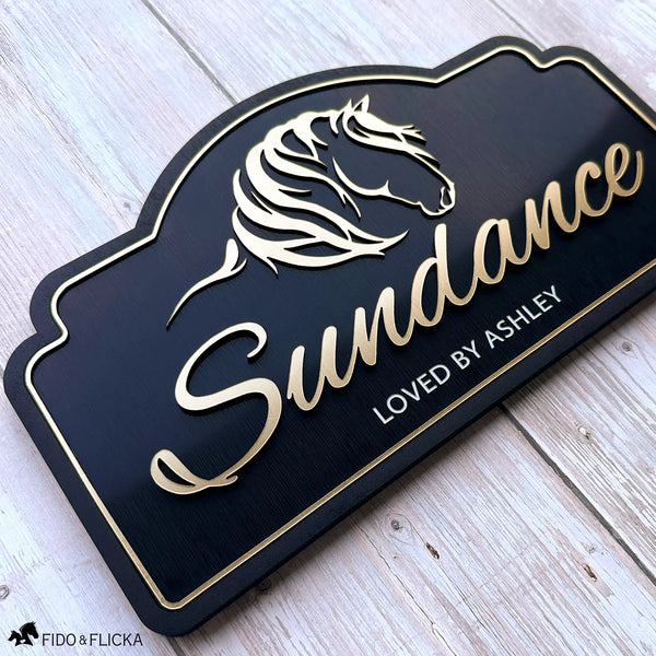 Custom horse stall sign featuring brushed gold acrylic horse artwork and custom name on a black layered acrylic plaque.