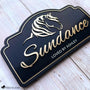 Custom horse stall sign featuring brushed gold acrylic horse artwork and custom name on a black layered acrylic plaque.