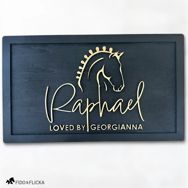 Elegant black wood horse stall nameplate featuring a gold silhouette of a braided show horse and the name “Raphael,” with the inscription “Loved by Georgianna.” Custom equestrian sign by Fido & Flicka, modern and personalized design.
