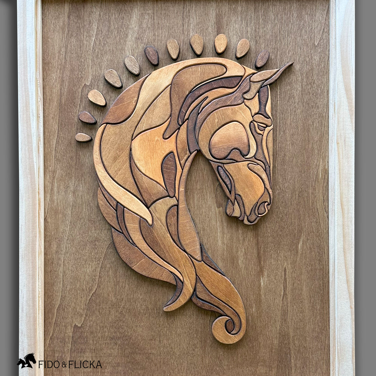 Close-up view of a handcrafted wooden horse head wall art featuring layered, stained wood pieces in natural tones, framed in light wood. The Baroque-style horse design showcases detailed contours and elegant curvature against a smooth wood background.