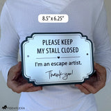 Brushed silver horse stall warning sign reading “Please Keep My Stall Closed, I’m an escape artist,” shown held in two hands for scale, 8.5