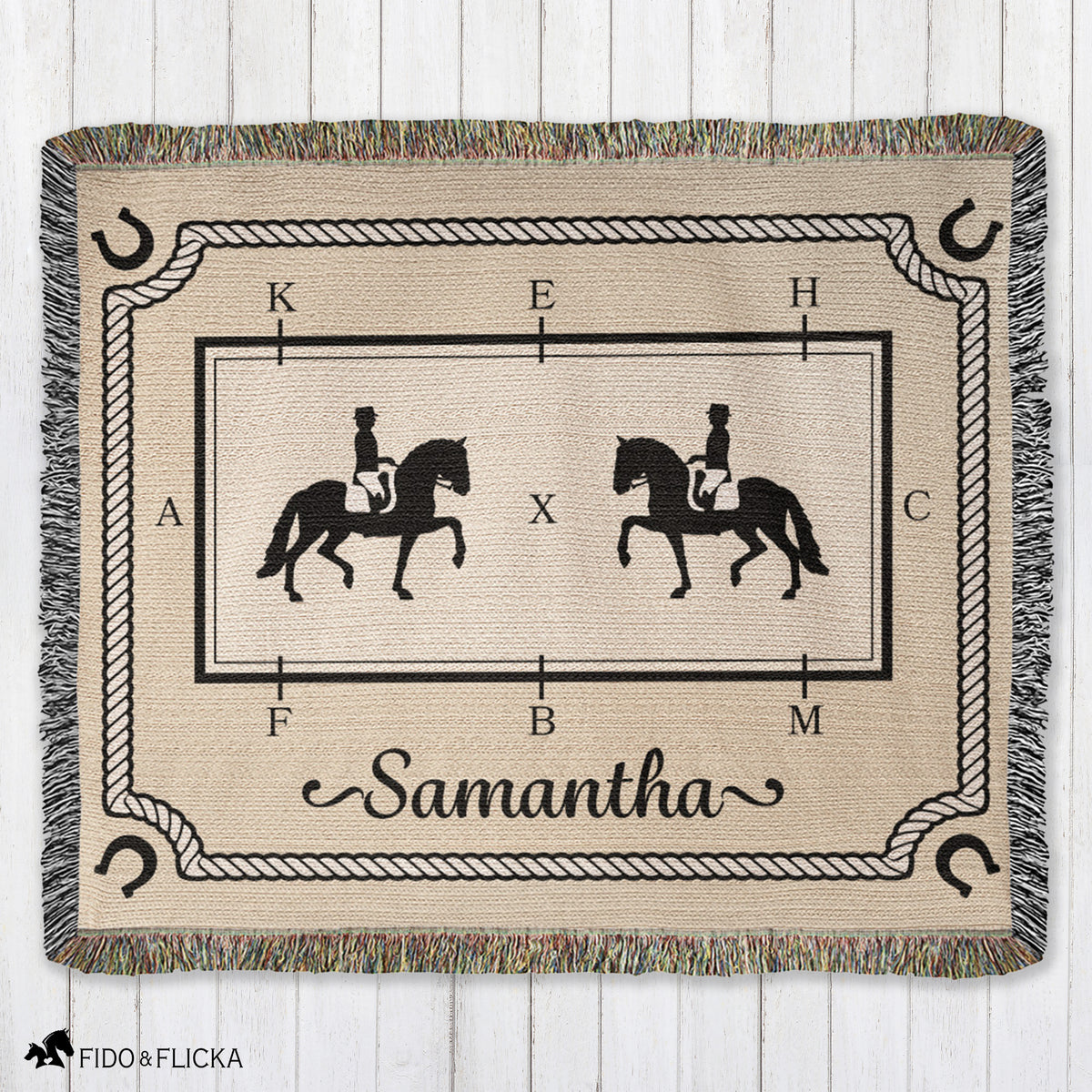 Woven blanket with horse and rider design and the name 'Samantha' on a wooden surface.