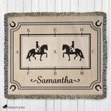 Woven blanket with horse and rider design and the name 'Samantha' on a wooden surface.