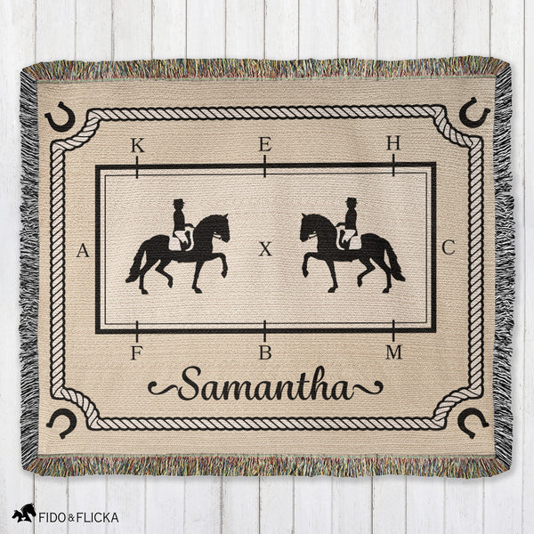Woven blanket with horse and rider design and the name 'Samantha' on a wooden surface.