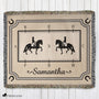 Woven blanket with horse and rider design and the name 'Samantha' on a wooden surface.