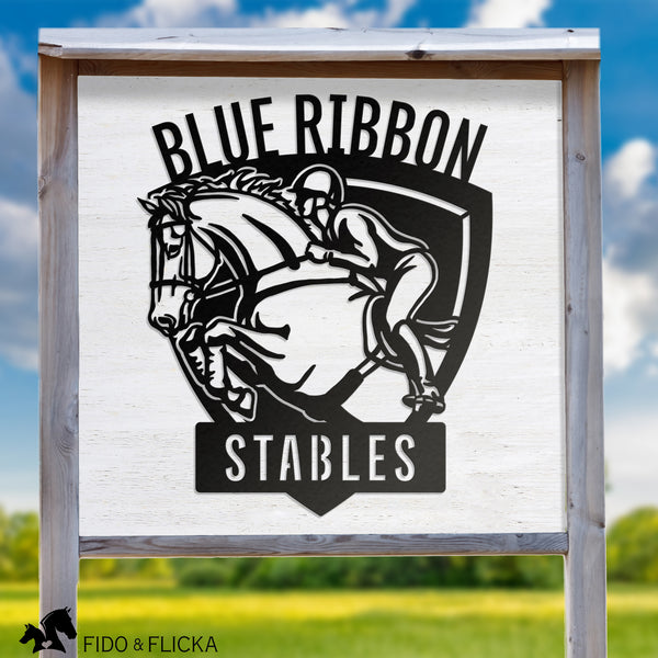 Custom metal stable sign featuring show jumping horse and rider with personalized text ‘Blue Ribbon Stables,’ displayed outdoors on a wooden sign frame against a rural landscape.