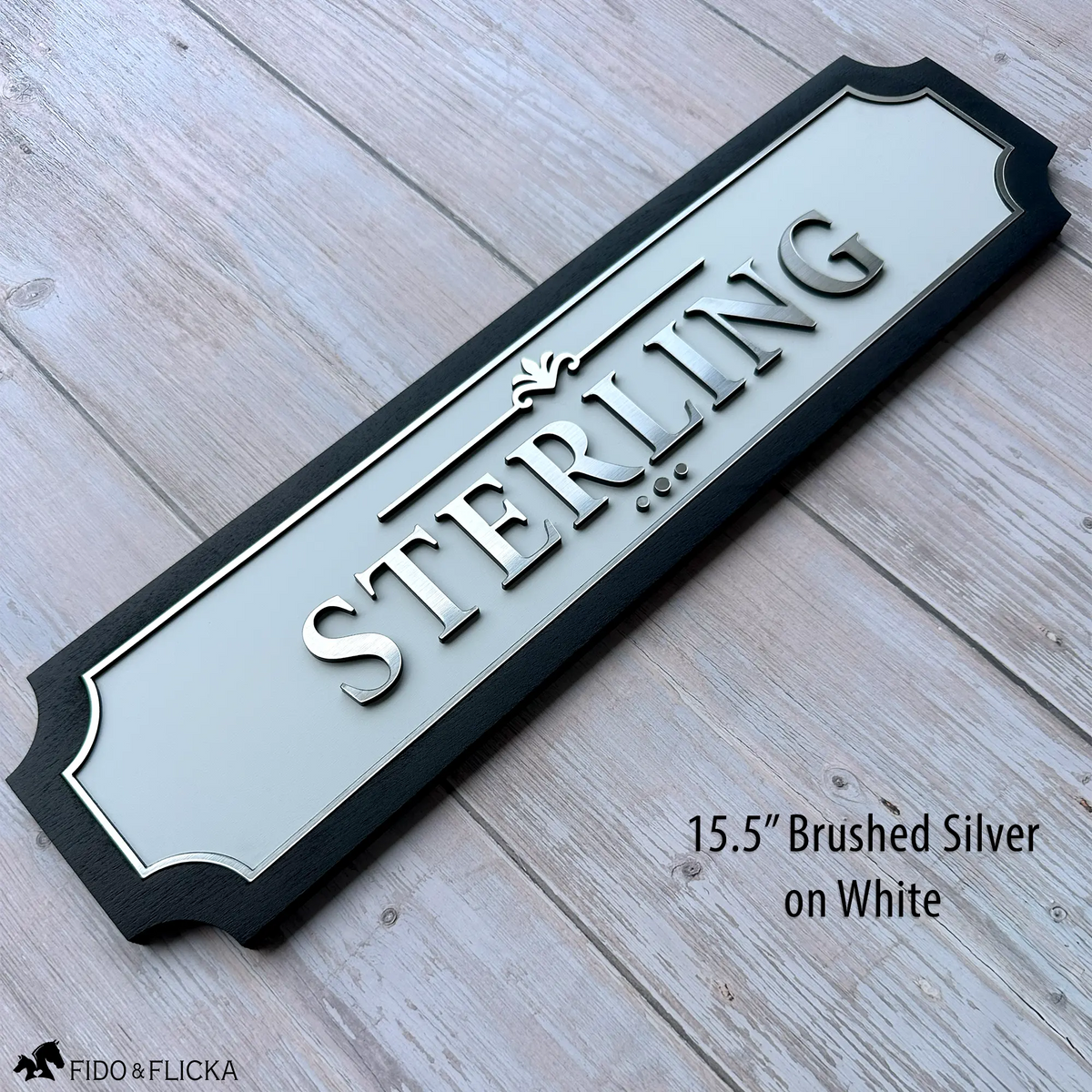 Personalized horse stall sign 15.5 inch extended size with raised brushed silver acrylic letters spelling STERLING on white acrylic base panel with sealed black wood frame by Fido and Flicka