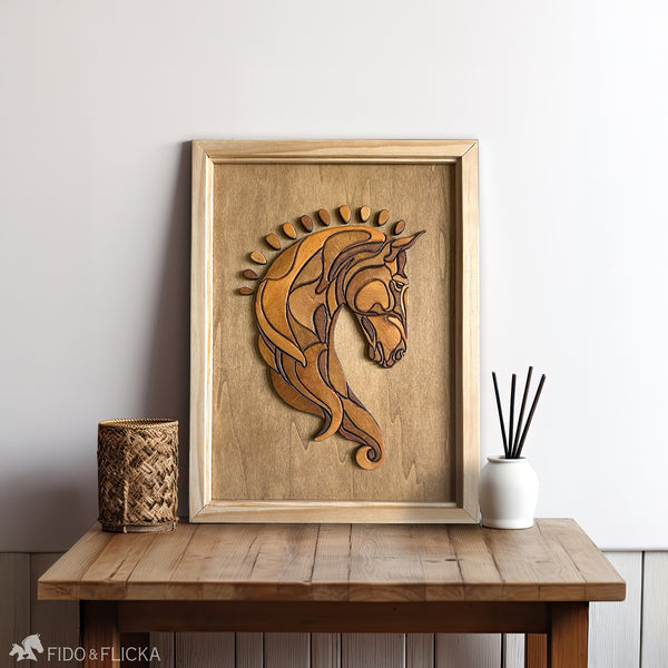 Handcrafted wood wall art featuring a Baroque-style horse head made from layered, stained wood pieces, framed in a natural wooden border. The artwork rests on a rustic wooden table between a woven candle holder and a white reed diffuser, set against a soft white wall.
