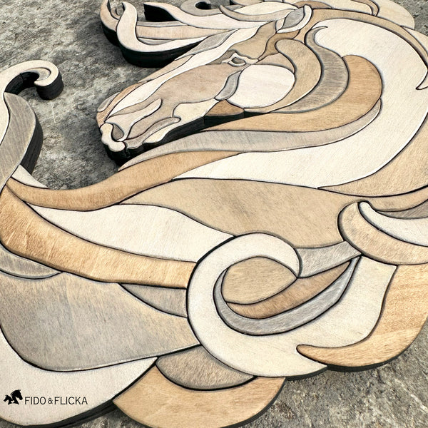 Close-up of Noble Drift wooden horse wall art by Fido & Flicka, showing layered curves and natural wood tones against a stone background