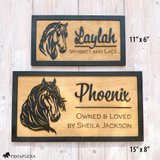 Two personalized wooden horse stall signs with black layered silhouettes of horses and raised script names. The top sign, measuring 11